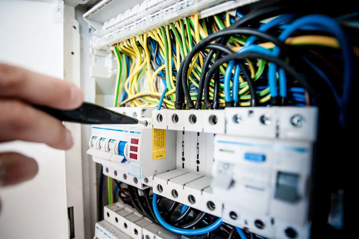 Electrician working on a switchboard with circuit breakers