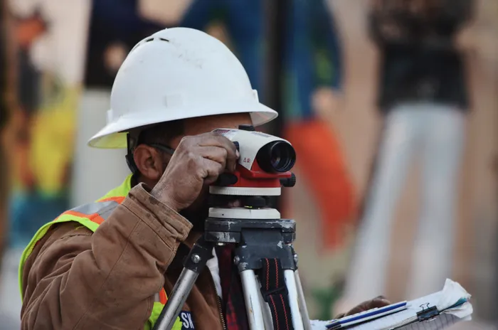 Surveyor using a level on a construction site